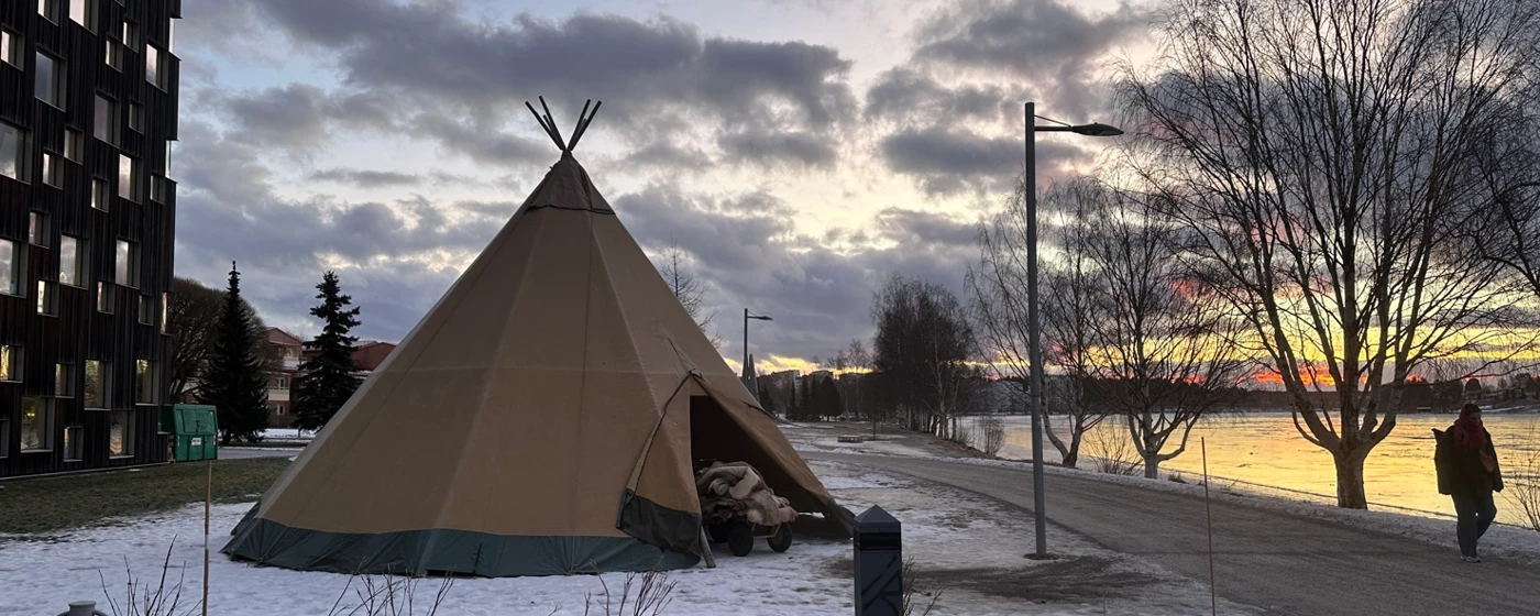 En tipi som sitter på toppen av en snötäckt mark.