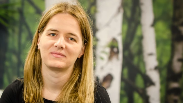 En kvinna i svart tröja som tittar mot kameran