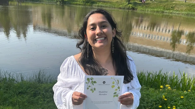 New graduate by the campus pond at Umeå University 