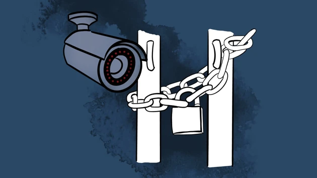 A padlock with a chain around a door opening and a surveillance camera.