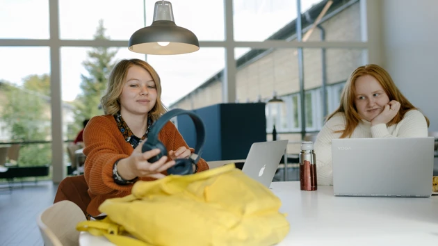 Två kvinnliga studenter sitter i Humanisthuset och pluggar. 
